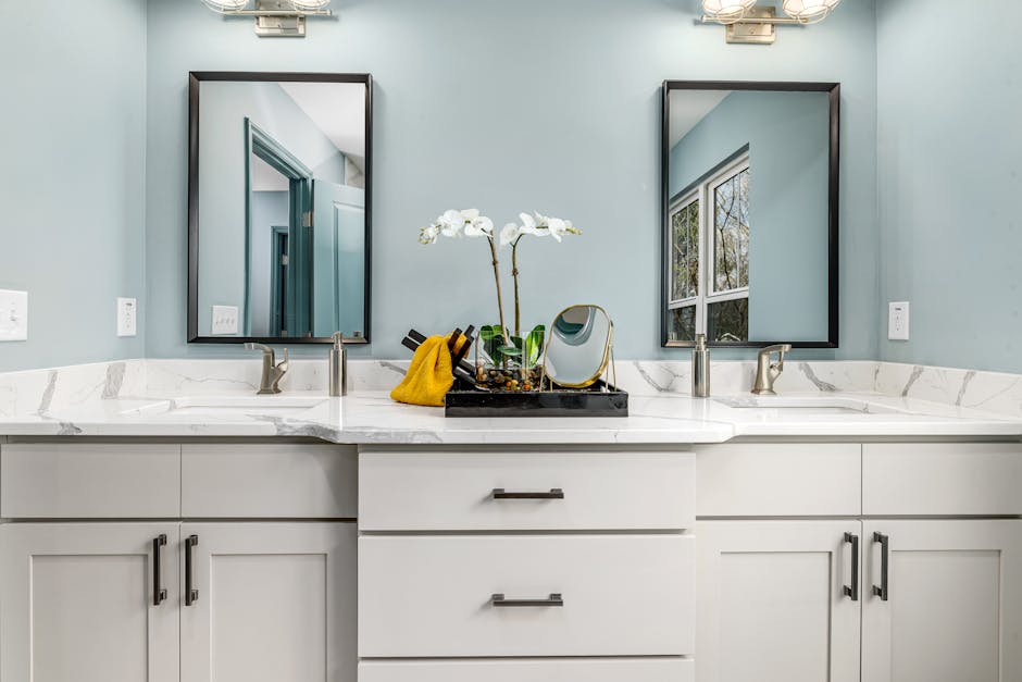 A serene modern bathroom featuring twin sinks, elegant faucets, and decorative mirrors.