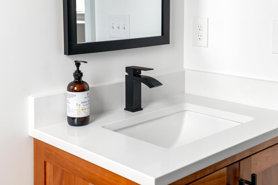 Stylish bathroom setup featuring a sleek black faucet, wall mirror, and elegant countertop.